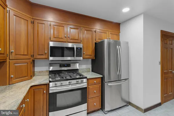 a kitchen with stainless steel appliances granite countertop a refrigerator stove and microwave