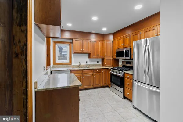 a kitchen with a refrigerator a sink and dishwasher with wooden cabinets