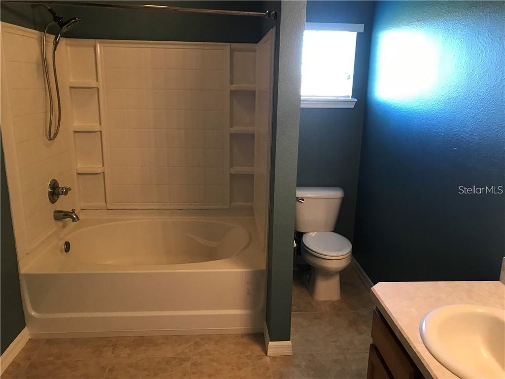 7542 Red Mill Circle New Port Richey, FL 34653 - Photo 19 of 27 a bathroom with a toilet and a tub
