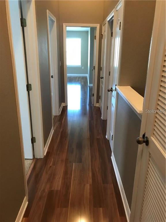 7542 Red Mill Circle New Port Richey, FL 34653 - Photo 23 of 27 a view of a hallway with wooden floor and staircase