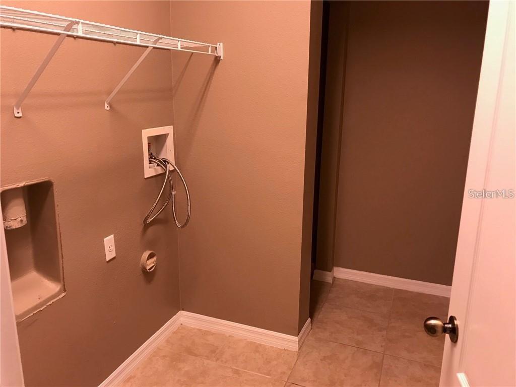 7542 Red Mill Circle New Port Richey, FL 34653 - Photo 24 of 27 a bathroom with a shower and a wooden door