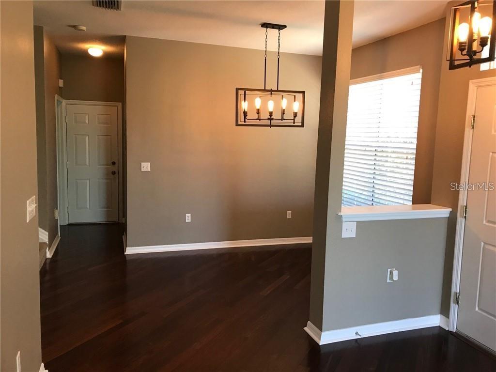 7542 Red Mill Circle New Port Richey, FL 34653 - Photo 6 of 27 a view of an empty room with wooden floor and a window