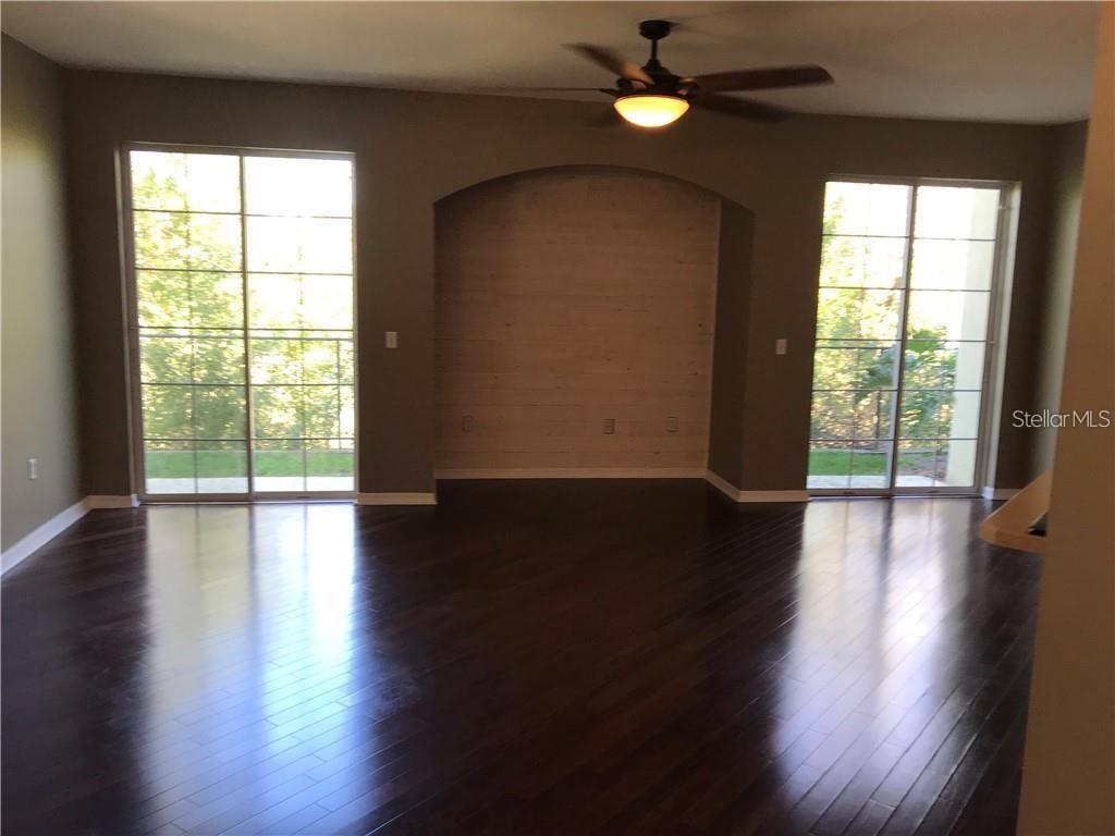 7542 Red Mill Circle New Port Richey, FL 34653 - Photo 7 of 27 a view of an empty room with wooden floor and a window