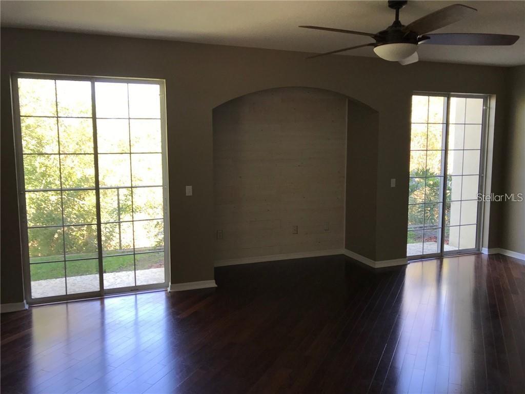 7542 Red Mill Circle New Port Richey, FL 34653 - Photo 8 of 27 a view of an empty room with wooden floor and a window