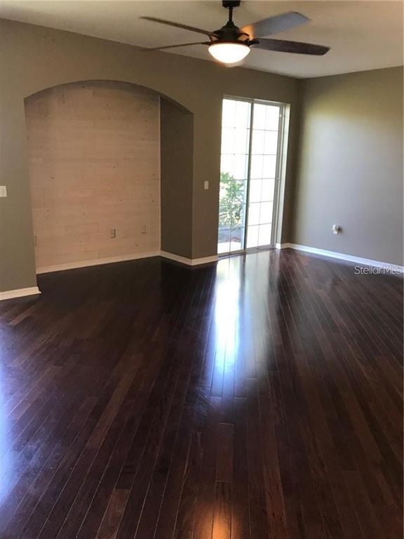 7542 Red Mill Circle New Port Richey, FL 34653 - Photo 9 of 27 a view of an empty room with wooden floor and a window