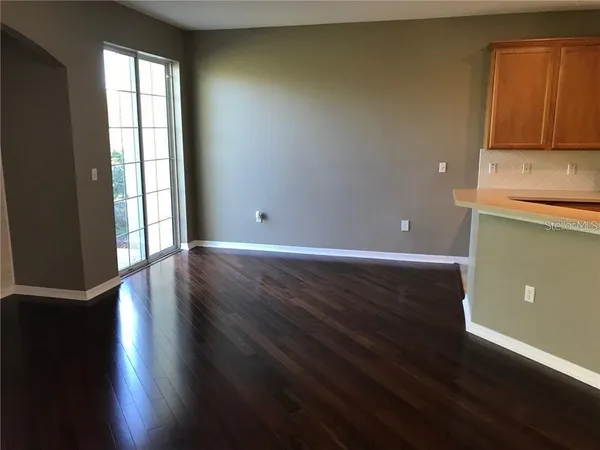 a view of a kitchen with wooden floor and a window