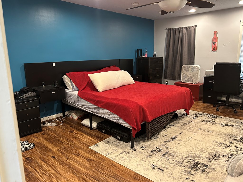 2125 13th Street, Unit 12 Columbus, GA 31906 - Photo 15 of 17 a bedroom with a bed and dresser with wooden floor