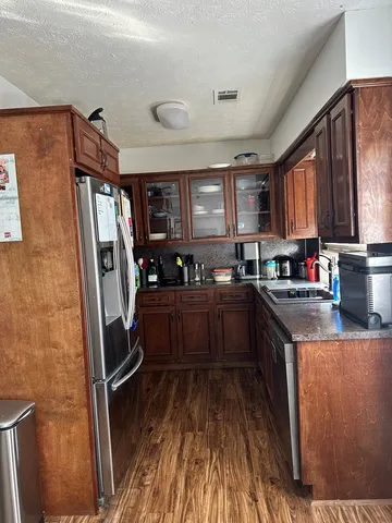 a kitchen with stainless steel appliances granite countertop a refrigerator stove top oven and sink