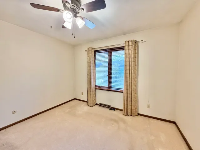 an empty room with chandelier fan