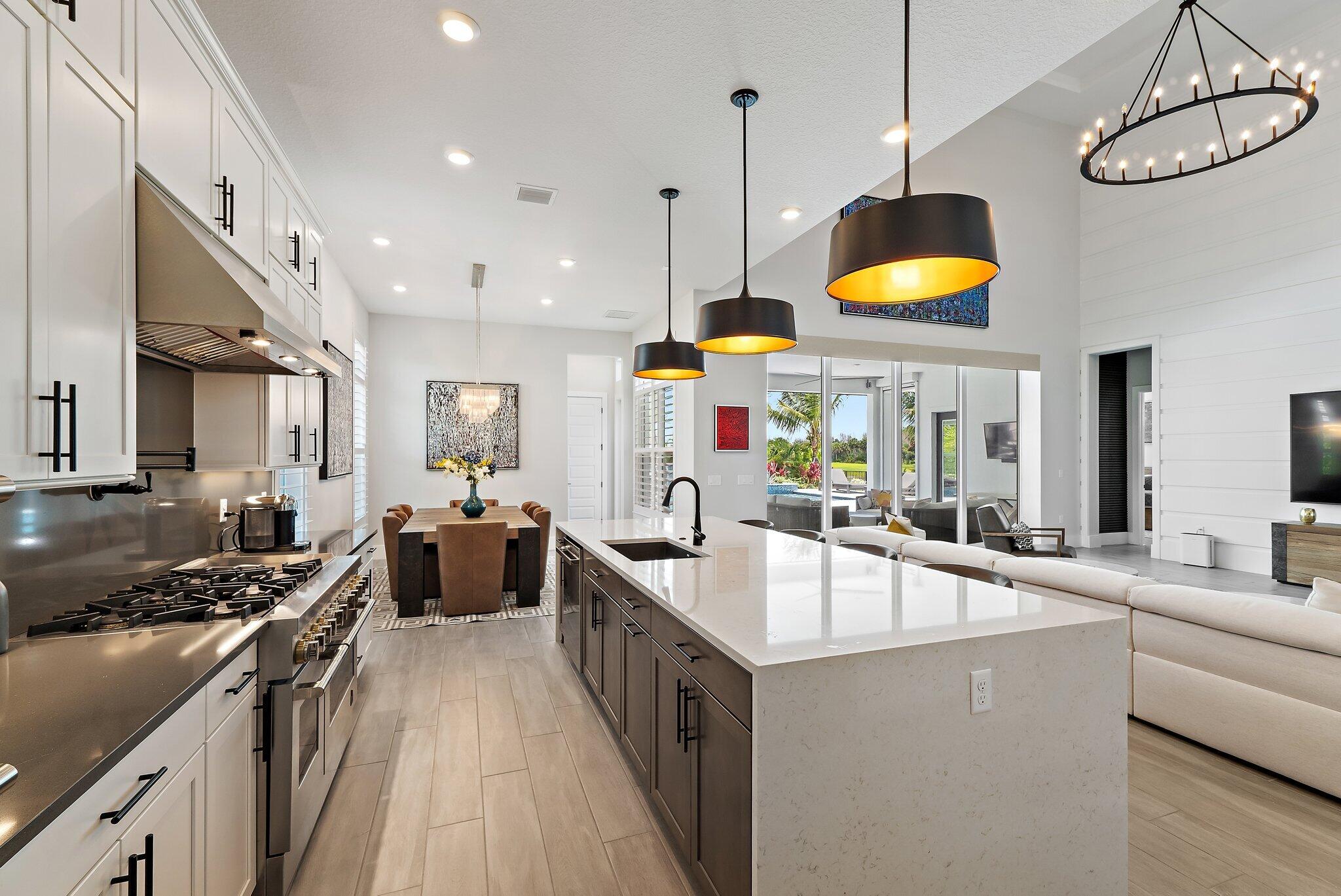 20049 Southeast Bridgewater Drive Jupiter, FL 33458 - Photo 57 of 77 a kitchen with stainless steel appliances a stove a sink a oven a counter space and living room view