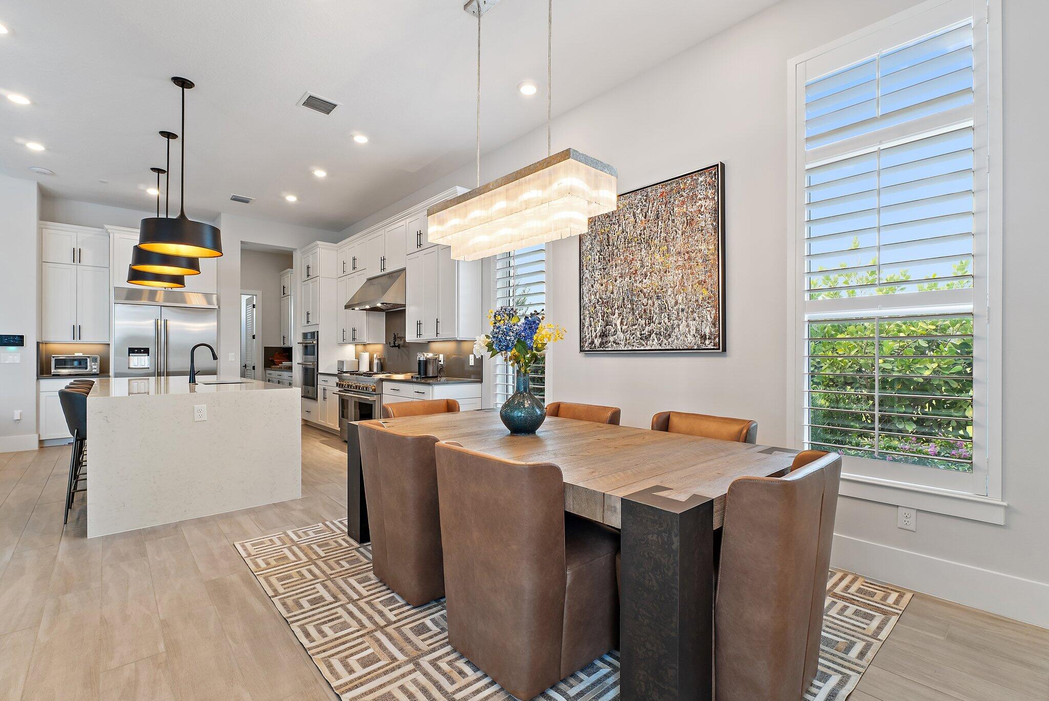 20049 Southeast Bridgewater Drive Jupiter, FL 33458 - Photo 8 of 77 a kitchen with stainless steel appliances granite countertop a refrigerator a sink dishwasher a dining table and chairs with wooden floor