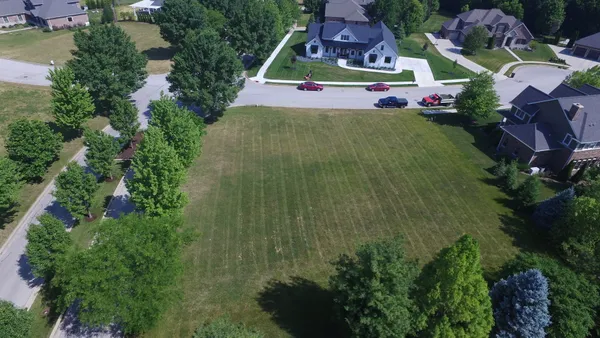 an aerial view of residential houses with outdoor space and street view