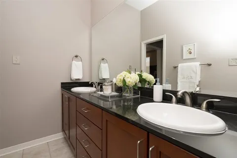 a bathroom with a double vanity sink and a toilet
