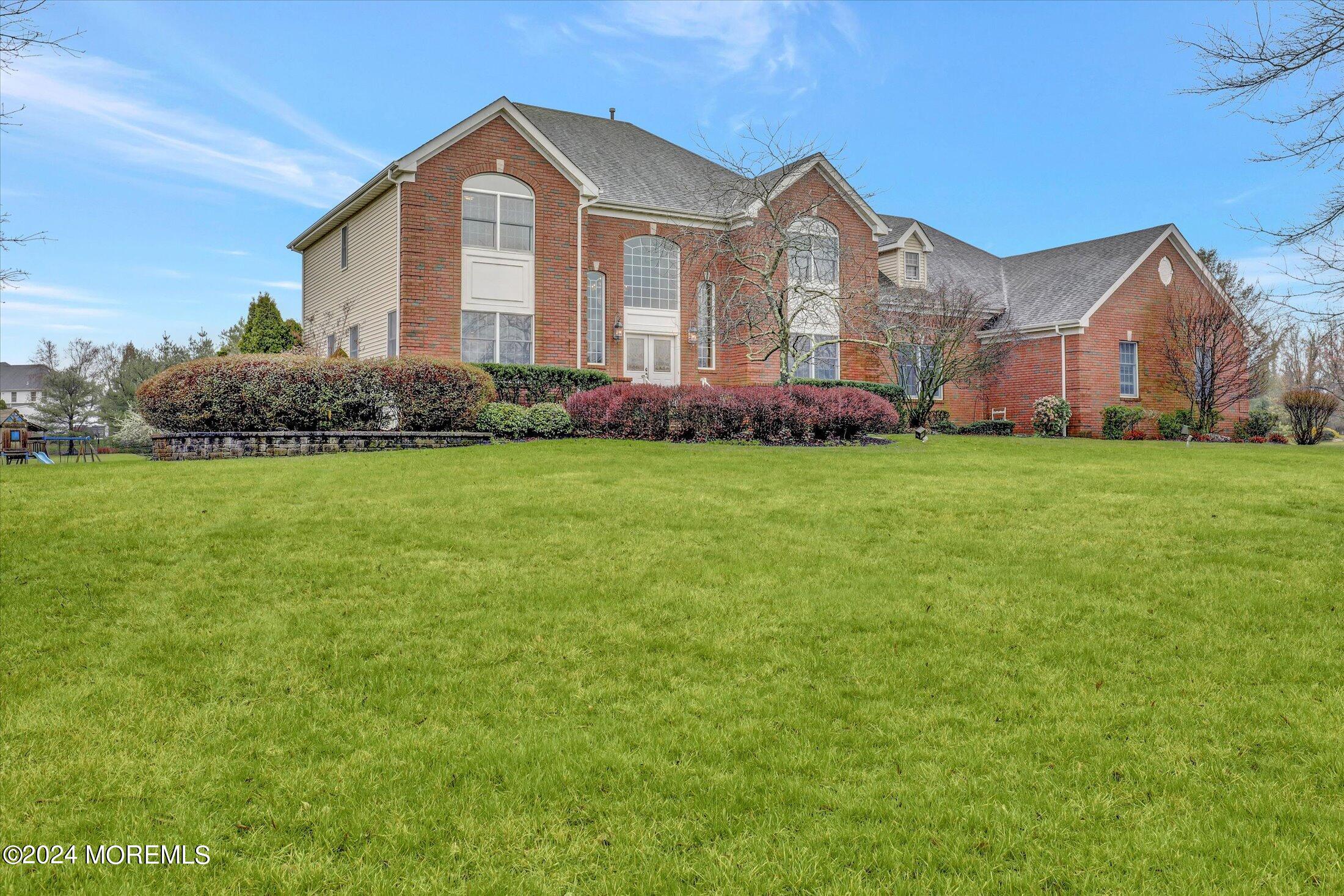 9 Shady Tree Lane Colts Neck, NJ 07722 - Photo 2 of 60 a front view of a house with a garden and porch