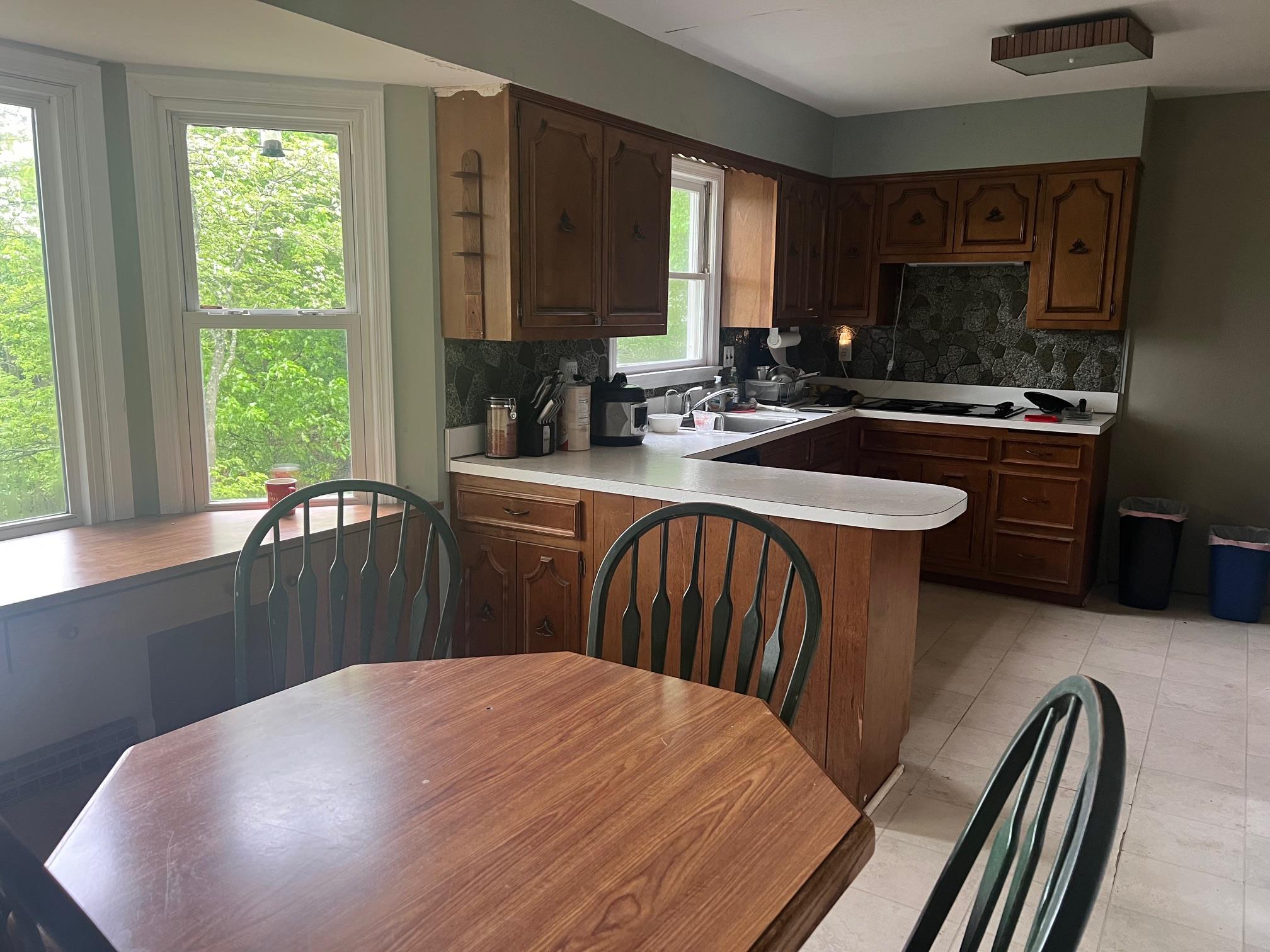 15 Old Field Road Setauket, NY 11733 - Photo 7 of 12 Kitchen featuring tasteful backsplash, light countertops, a peninsula, and a sink