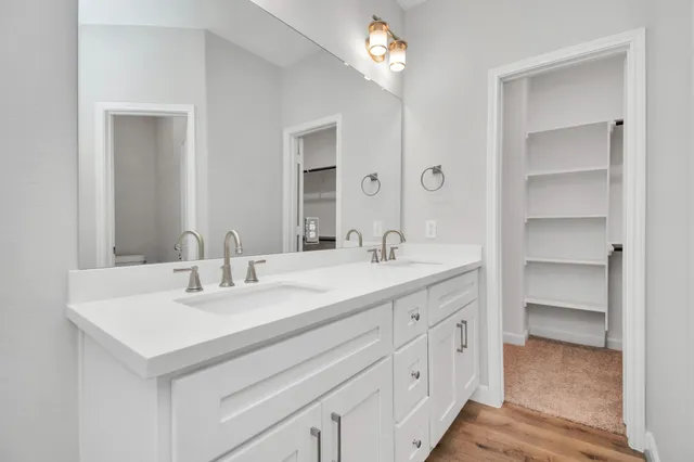a bathroom with a sink double vanity granite tub and a mirror