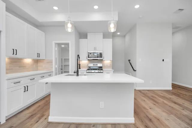 a kitchen with granite countertop a sink stainless steel appliances and cabinets