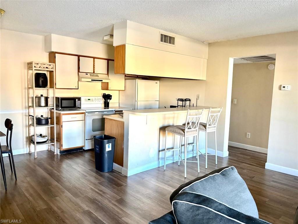 5315 Summerlin Road, Unit 1508 Fort Myers, FL 33919 - Photo 17 of 46 a living room with stainless steel appliances furniture wooden floor and a table