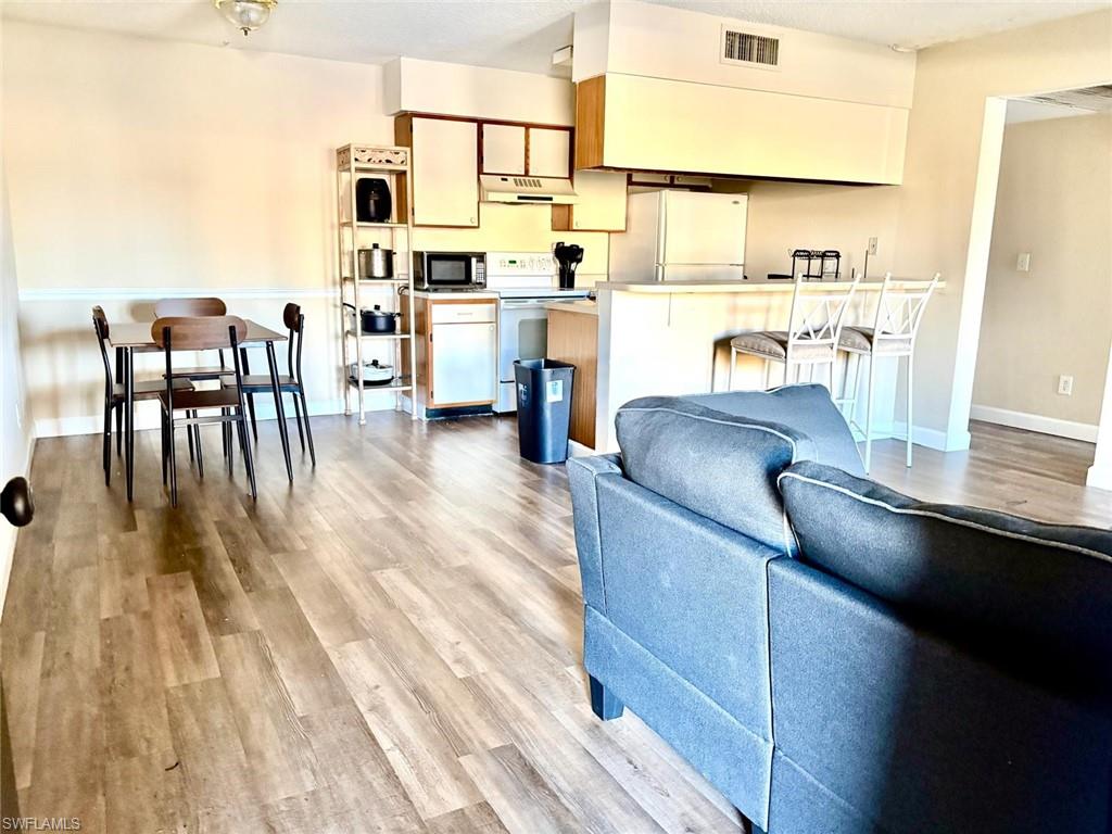 5315 Summerlin Road, Unit 1508 Fort Myers, FL 33919 - Photo 20 of 46 a living room with stainless steel appliances granite countertop furniture wooden floor and a kitchen view