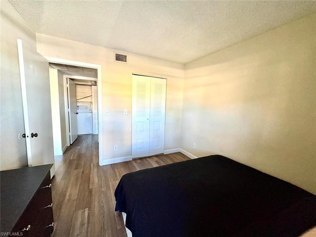 5315 Summerlin Road, Unit 1508 Fort Myers, FL 33919 - Photo 28 of 46 a bedroom with a bed and wooden floor