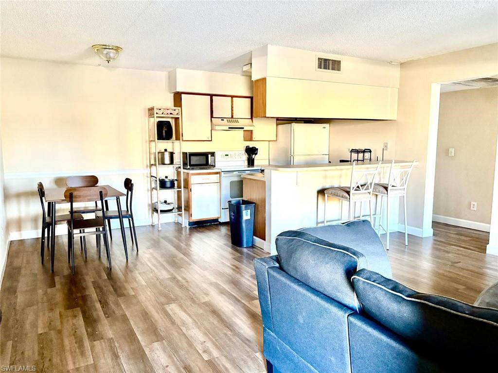 5315 Summerlin Road, Unit 1508 Fort Myers, FL 33919 - Photo 31 of 46 a living room with stainless steel appliances furniture wooden floor and a kitchen view