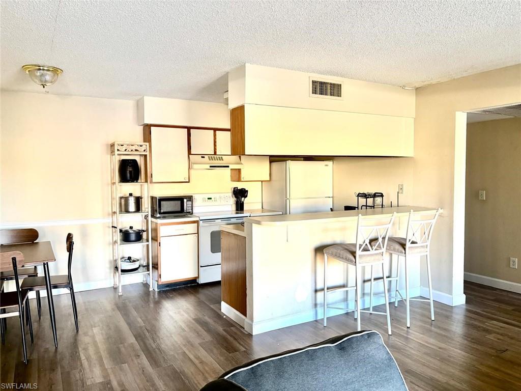 5315 Summerlin Road, Unit 1508 Fort Myers, FL 33919 - Photo 32 of 46 a kitchen with stainless steel appliances a stove top oven a sink a dining table and chairs