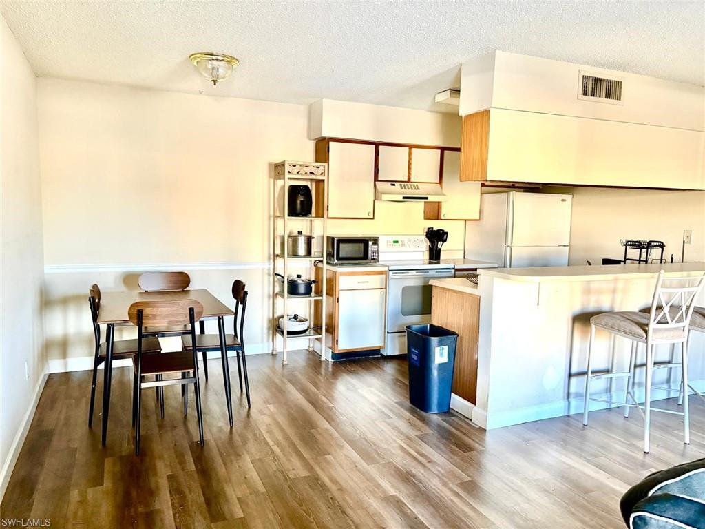 5315 Summerlin Road, Unit 1508 Fort Myers, FL 33919 - Photo 33 of 46 a dining room with furniture and wooden floor