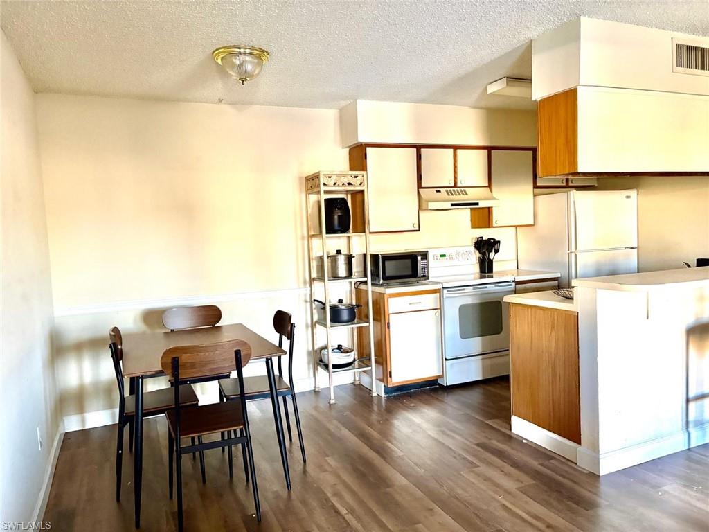 5315 Summerlin Road, Unit 1508 Fort Myers, FL 33919 - Photo 38 of 46 a kitchen with granite countertop white cabinets and white appliances