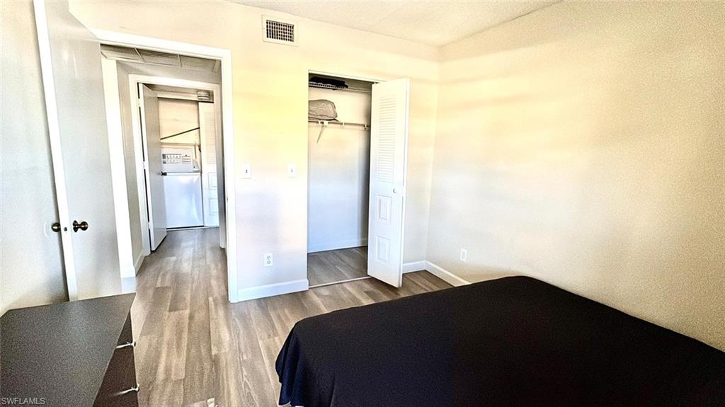 5315 Summerlin Road, Unit 1508 Fort Myers, FL 33919 - Photo 39 of 46 a bedroom with a bed and wooden floor