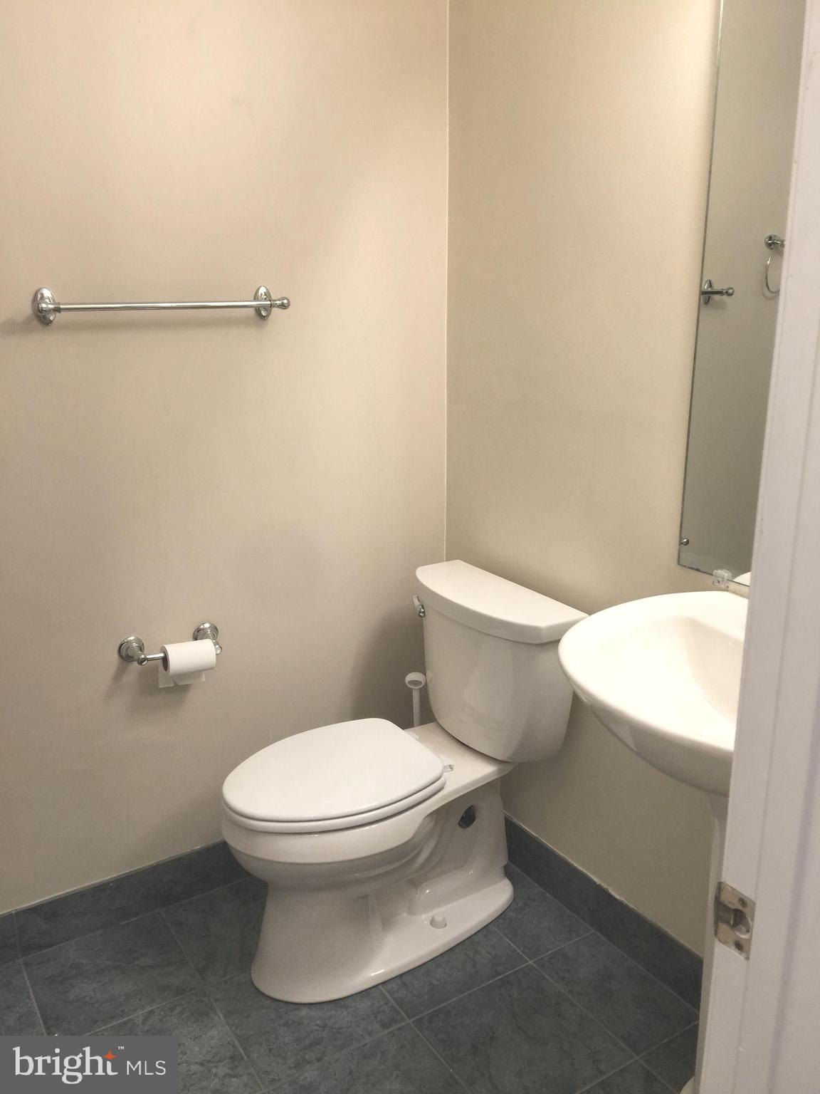 10715 Kings Riding Way, Unit 202 North Bethesda, MD 20852 - Photo 11 of 17 a white toilet sitting next to a bathroom sink and vanity