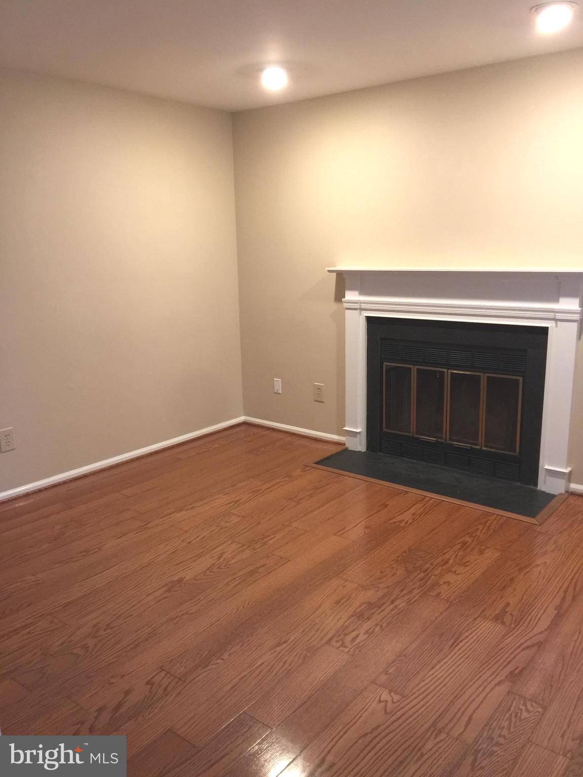 10715 Kings Riding Way, Unit 202 North Bethesda, MD 20852 - Photo 7 of 17 a view of empty room with wooden floor and fireplace
