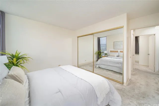 a bedroom with a bed and a potted plant