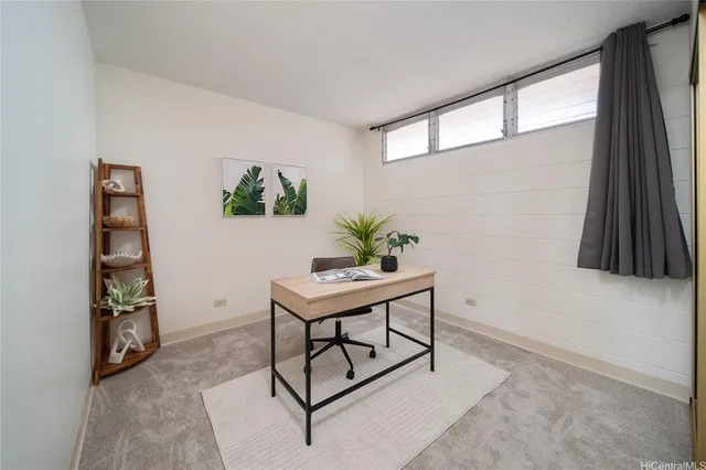 a view of a workspace with furniture and a window