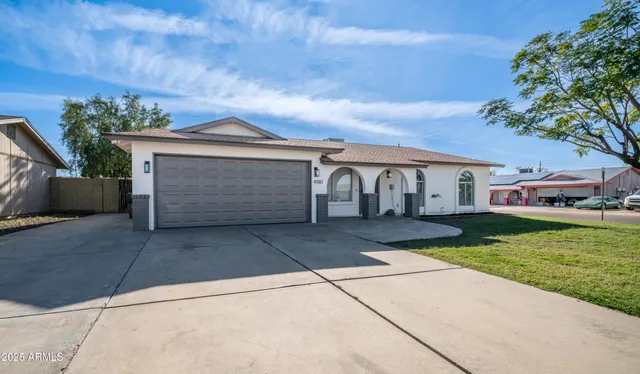 a front view of a house with a yard and a garage