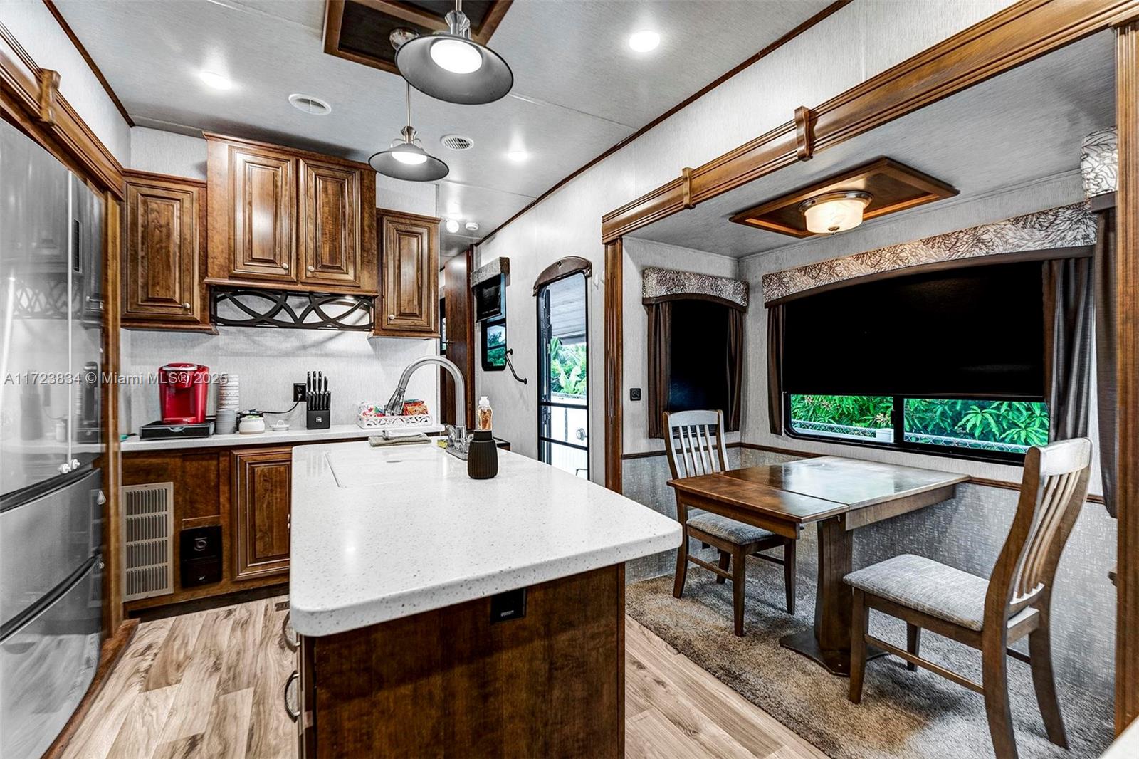1111 Brown Road Lake Worth, FL 33462 - Photo 53 of 63 a kitchen with stainless steel appliances kitchen island granite countertop a stove a sink and a microwave