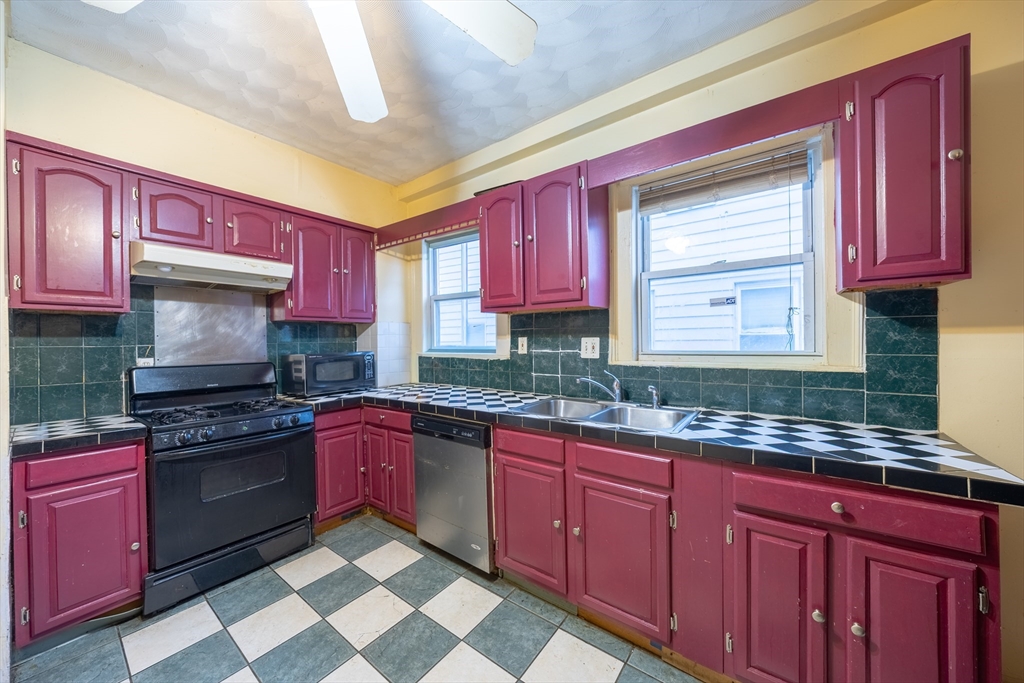 31 Seattle Street, Unit 1 Boston, MA 02134 - Photo 13 of 31 a kitchen with granite countertop stainless steel appliances a sink stove top oven and cabinets