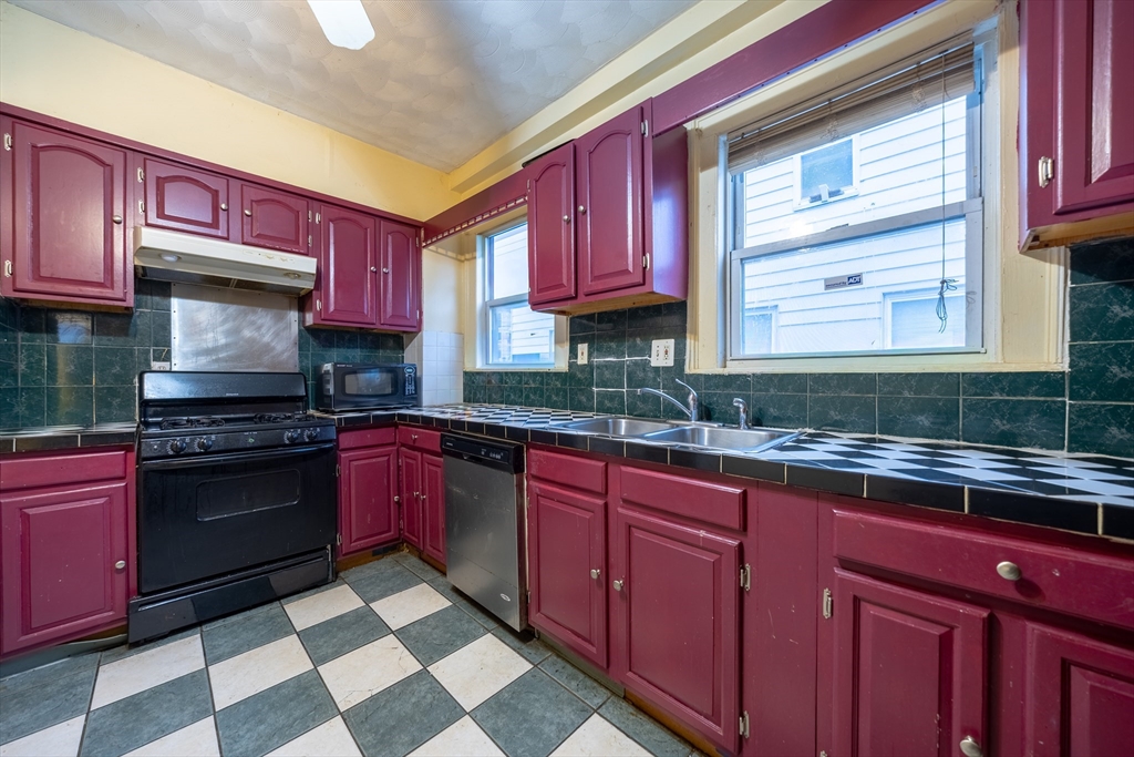 31 Seattle Street, Unit 1 Boston, MA 02134 - Photo 14 of 31 a kitchen with stainless steel appliances granite countertop a sink stove and cabinets