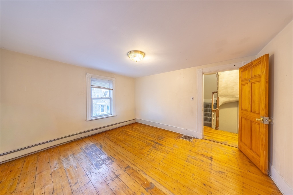 31 Seattle Street, Unit 1 Boston, MA 02134 - Photo 20 of 31 a view of an empty room with a window and wooden floor