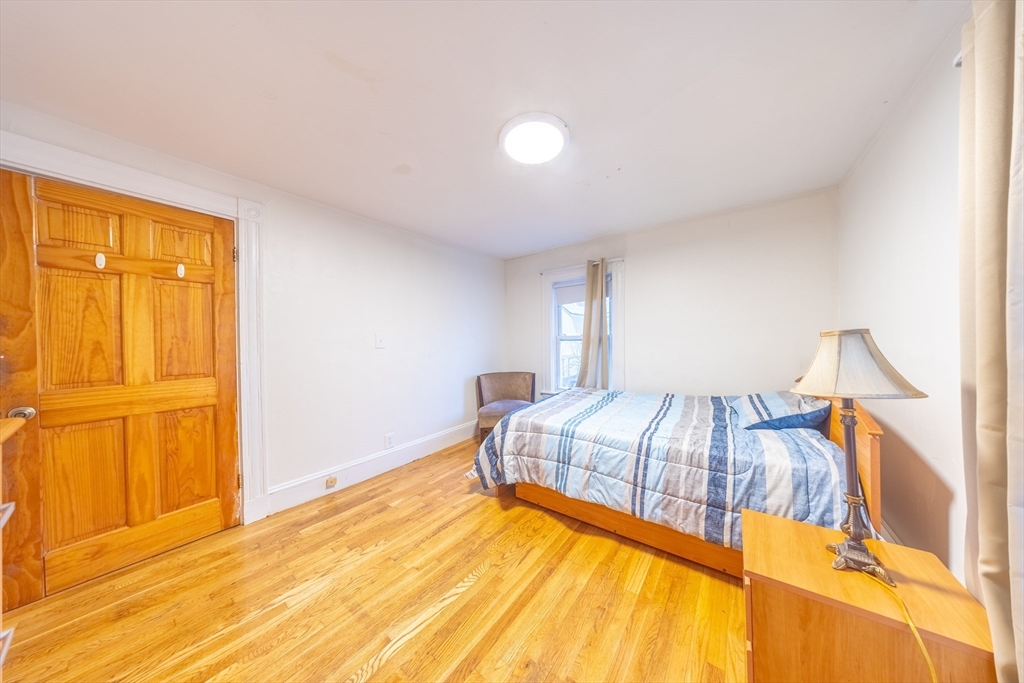 31 Seattle Street, Unit 1 Boston, MA 02134 - Photo 24 of 31 a view of a bedroom with a bed and wooden floor