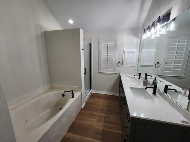 a bathroom with a tub sink and mirror
