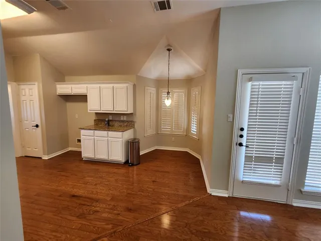 a kitchen with granite countertop a stove a sink and a refrigerator