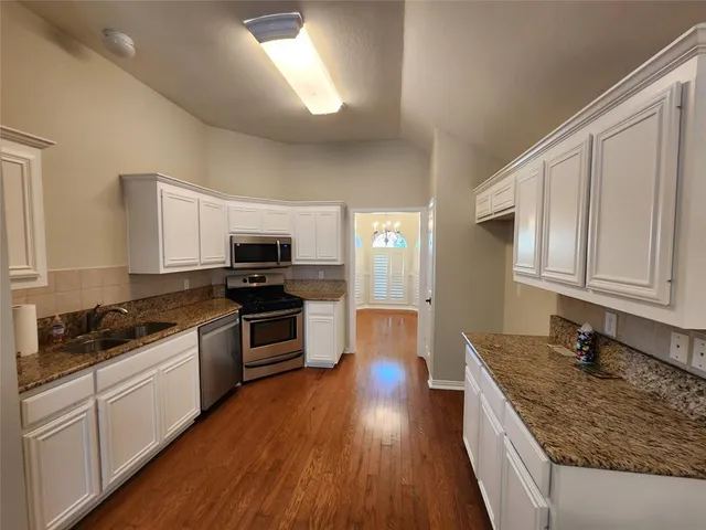 a kitchen with granite countertop a sink and steel appliances