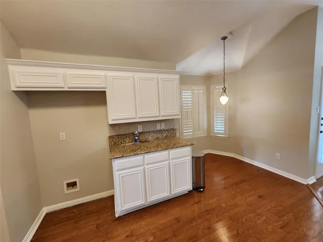 a kitchen with granite countertop white cabinets and white appliances