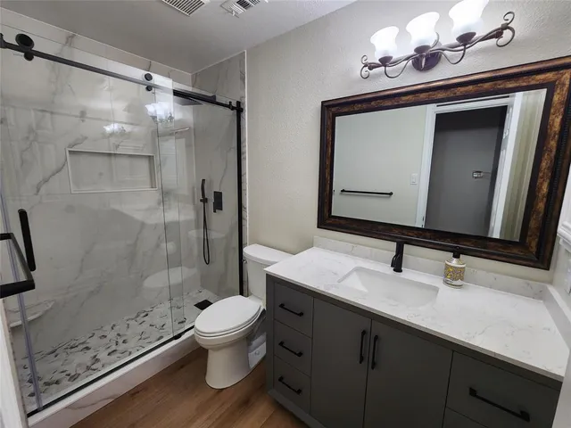 a bathroom with a sink a toilet and shower