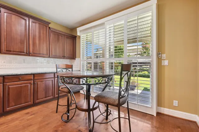 a kitchen with a table chairs and wooden cabinets
