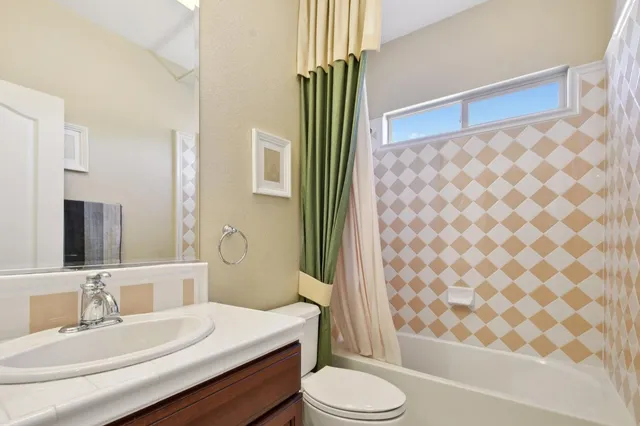 a bathroom with a sink a toilet a mirror and shower