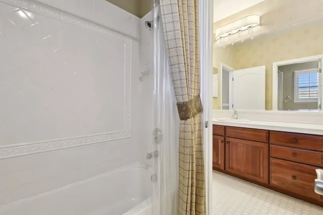 a bathroom with a granite countertop sink a mirror and a bathtub