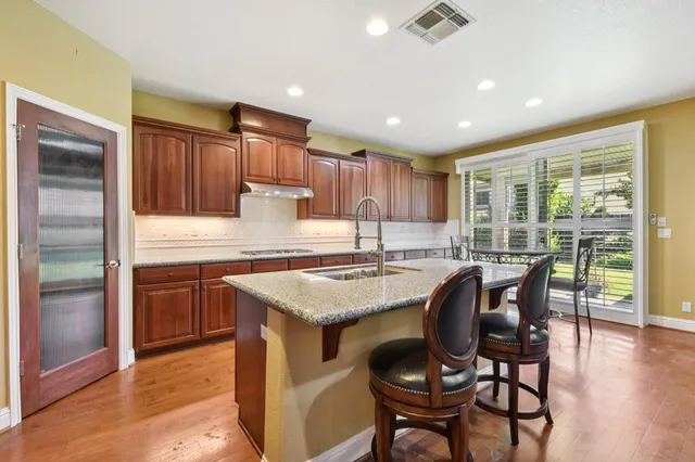 a kitchen with a table chairs refrigerator and cabinets
