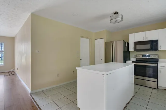 a kitchen with a stove a microwave and a refrigerator