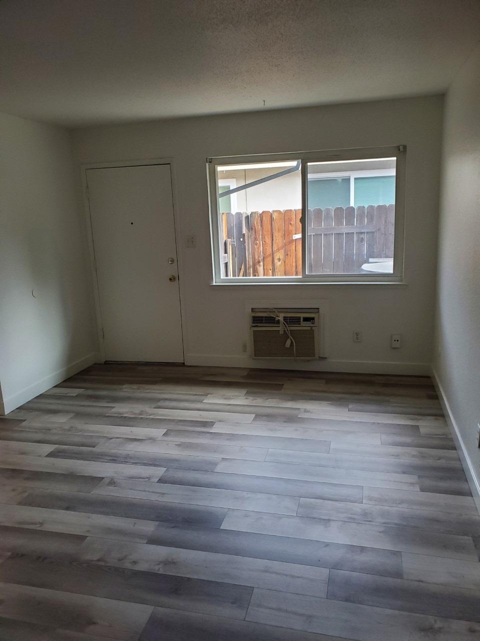 6012-6014 Bourbon Drive Carmichael, CA 95608 - Photo 8 of 30 a view of empty room with wooden floor and fan
